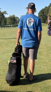 An attendee with a service dog at the military charity golf tournament
