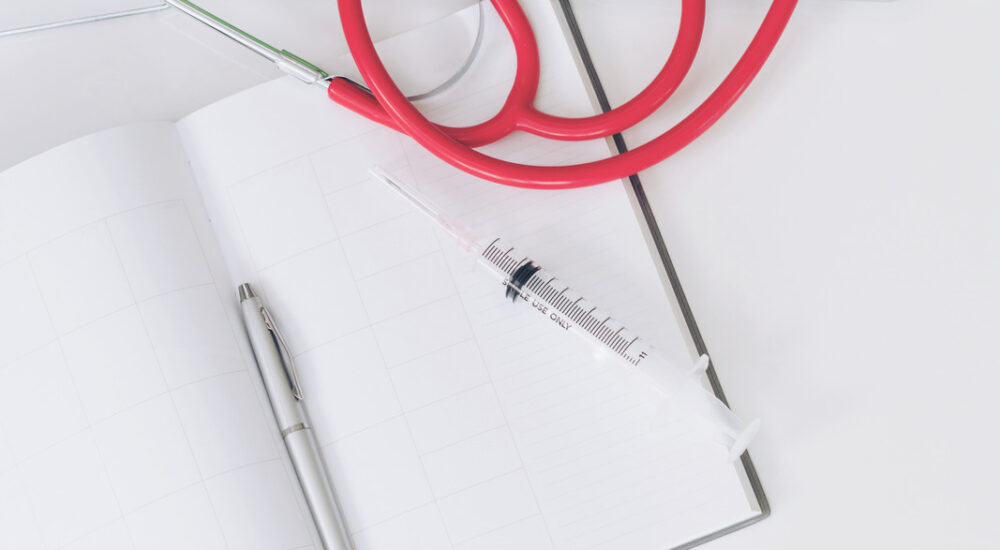 Medical healthcare backgrounds flat lay objects. Medical healthcare backgrounds flat lay objects with copy space. Doctor stethoscope, medicine, laptop computer and notebook on white office table.
